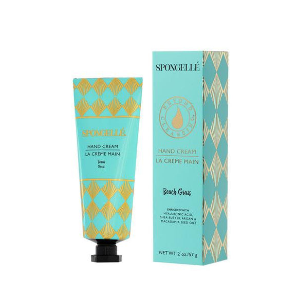 A blue box from Spongelle to the right with a blue bottle of Spongelle's Beach Grass 2oz Hand Lotion to the left that comes in the box. 