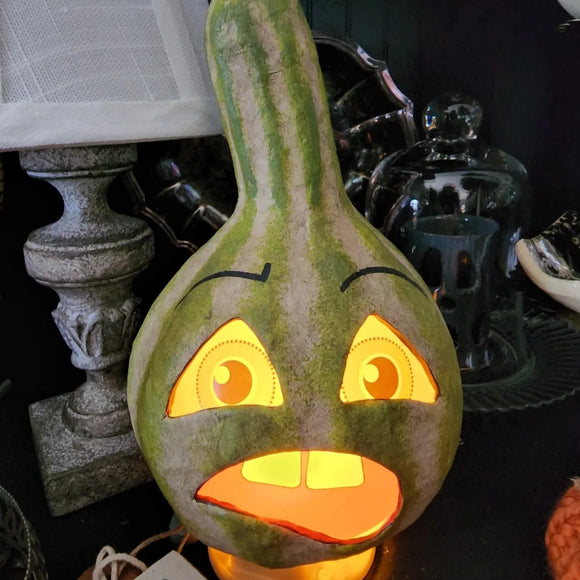 This grouchy gourd has vintage-style printed vellum inserts with an opening in the bottom for a battery-operated light. Light him up for a glowing good time at your Halloween Soiree!  Paper mache and vellum.  Approximately 9.5