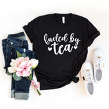 We know you're a tea lover, but does anyone else?  If you drink tea as we do, you will love wearing this "Fueled by Tea" t-shirt!  The white lettering is on a black t-shirt, pair it with your favorite jeans and flats!  SIZING Unisex. The fit is more relaxed than typical women’s shirts fit.  CARE - Turn the garment inside out and wash cold on a delicate cycle. - Lay flat to dry. - Do not bleach, dry clean, or iron directly onto the design. Made in Canada