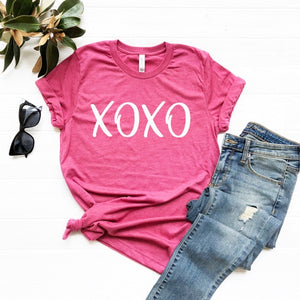 What a fun way to bring in Valentine's Day! Our hugs & kisses tee is in a beautiful heathered raspberry color with "XOXO" lettering in white. These are so soft & comfy, you will love wearing them to get-togethers, shopping or just running around doing errands. The styling possibilities are endless. Roll up the sleeves, tie a side knot, front tuck, or wear it while lounging around the house. We guarantee that you will love the fit and the softness of this shirt.