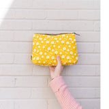 These sweet daisies on a yellow background make such a cute & happy print! All of our bags are printed on recycled canvas with eco-friendly pigment inks. This small pouch is ideal for daily essentials or as a clutch. The interior waterproof lining makes cleaning a breeze, and the zipper ring hooks nicely onto our totes... easy peasy!  5” x 4” x 1” Made in India